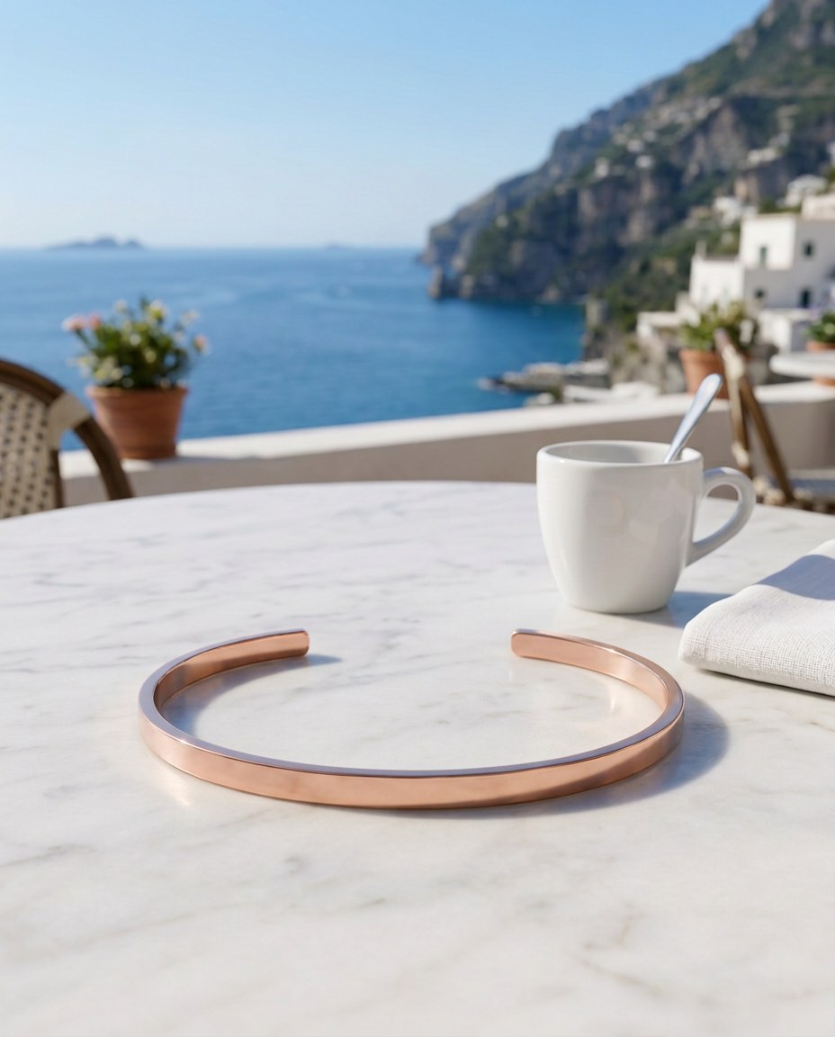 The Capri Slim Flat Bracelet su un tavolo di marmo con espresso e mare di Capri