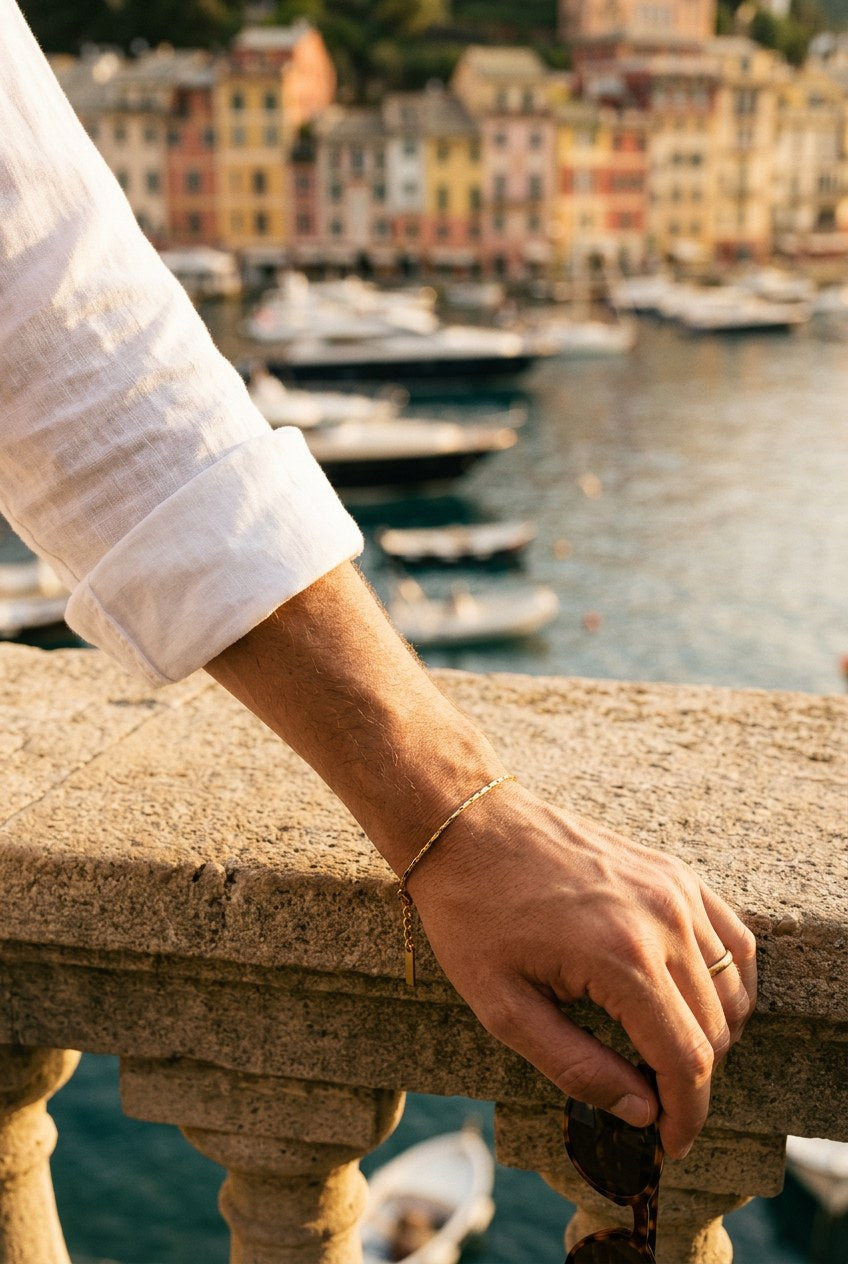 Handgelenk mit The Royal Wire Bracelet auf einer Balustrade über dem Hafen von Portofino
